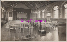 Load image into Gallery viewer, Vintage black and white photo of a large room with rows of chairs and a stage, labeled 'Mo's Postcards'.