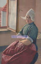 Load image into Gallery viewer, Woman in a red dress and white headscarf sitting by a window, with 'Volendam' text.