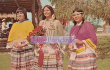 Load image into Gallery viewer, Three women in traditional attire standing outdoors with a 'Mo's Postcards' logo overlay.