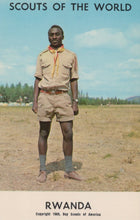 Load image into Gallery viewer, Scout in uniform standing in a field with 'Scouts of the World' and 'Rwanda' text at the top.