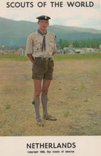 Load image into Gallery viewer, Scout in uniform standing outdoors with text 'Scouts of the World Netherlands'
