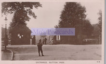 Load image into Gallery viewer, Vintage black and white photo of a person standing in front of a gate at Sutton Park, with 'Mo's Postcards' watermark.