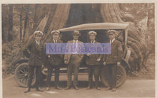 Load image into Gallery viewer, Group of men in formal attire standing next to an old-fashioned car in a forest setting.