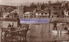 Load image into Gallery viewer, Vintage black and white photo of a harbor scene with people and a cart in the water, buildings in the background.