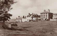 Load image into Gallery viewer, Vintage black and white photo of a village scene with houses and a car on Constitution Hill, Southwold.