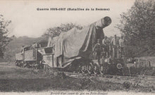 Load image into Gallery viewer, Vintage postcard showing a large artillery piece being transported on a train, with soldiers around it, set against a natural landscape.