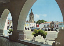 Load image into Gallery viewer, Town square with a clock tower and arches, featuring a cart with plants.