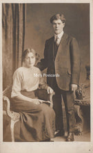 Load image into Gallery viewer, Vintage photograph of a man and woman posing together in formal attire against a curtain backdrop.