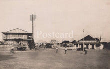 Load image into Gallery viewer, Vintage black and white photo of a sports field with buildings and people