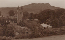 Load image into Gallery viewer, Vintage sepia-toned photograph of a village with a church and surrounding landscape.