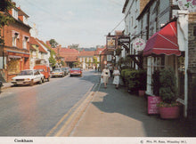 Load image into Gallery viewer, Vintage street scene in a small town with shops and cars.