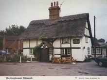 Load image into Gallery viewer, Traditional English pub with thatched roof in Tidmarsh, featuring a sign for 'The Greyhound'.
