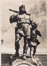 Load image into Gallery viewer, Black and white statue of a man with a child on his shoulders, with a castle in the background.