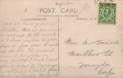 Vintage postcard with handwritten text and a postage stamp on a beige background