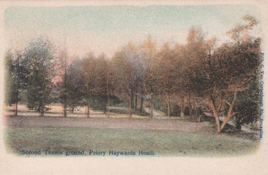 Vintage postcard of a park with trees and grass, labeled 'Second Tennis ground, Priory Haywards Heath'.