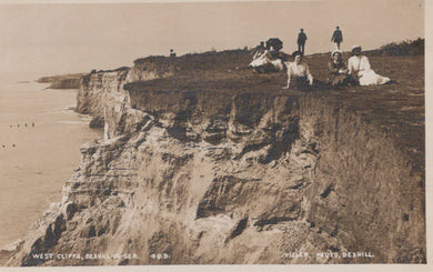 Vintage photograph of people sitting on a cliff edge with a beach in the background
