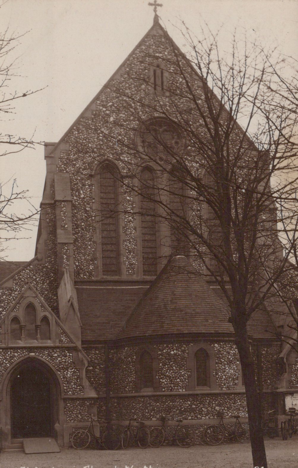 Vintage photograph of a church with a prominent steeple and arched entrance.