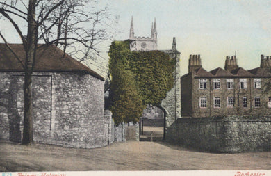 Vintage colorized postcard of a street scene with buildings and a church spire.