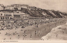 Load image into Gallery viewer, Vintage black and white photo of a crowded beach with buildings in the background
