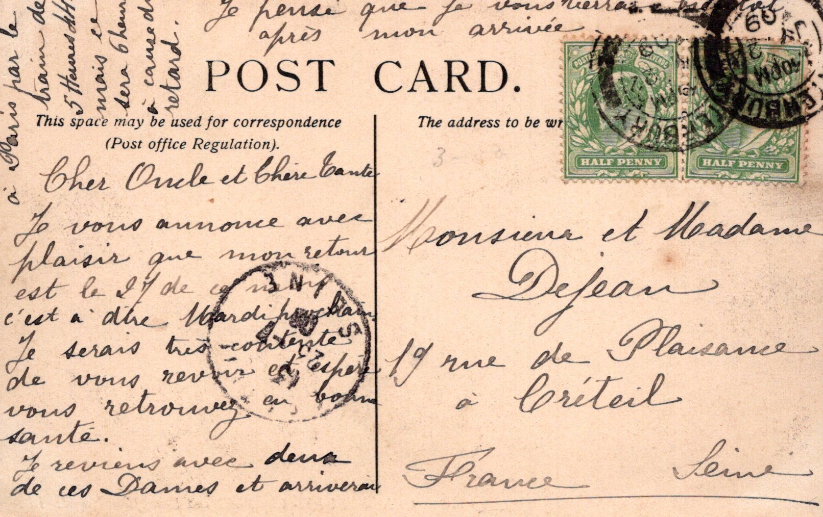 Vintage postcard with stamps and cursive writing, featuring a green stamp and a red stamp.
