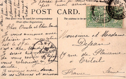Vintage postcard with stamps and cursive writing, featuring a green stamp and a red stamp.
