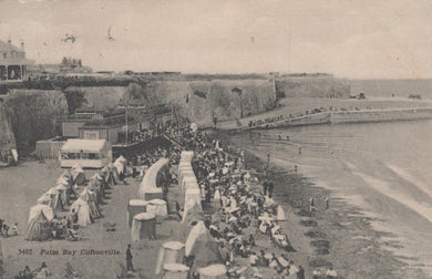 Vintage postcard of a beach scene with people and tents, likely from the early 20th century.