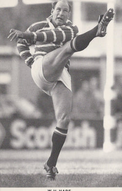 Black and white photo of a rugby player in action on a field with 'Scottish' branding.