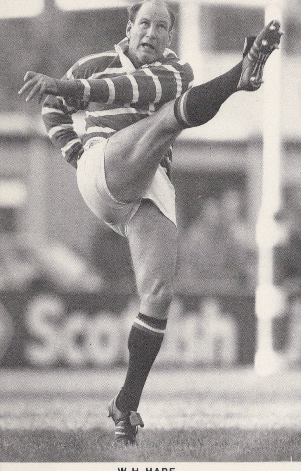 Black and white photo of a rugby player in action on a field with 'Scottish' branding.