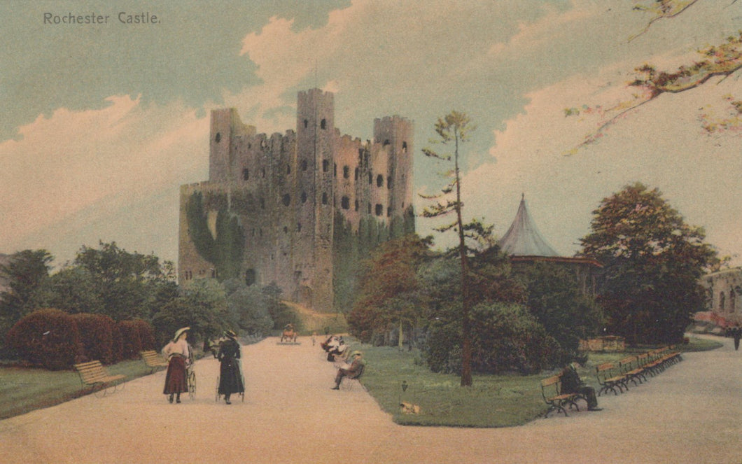 Rochester Castle with people walking in the foreground on a sunny day.