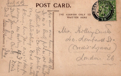 Vintage postcard with handwritten text and a stamp, featuring a brown background.