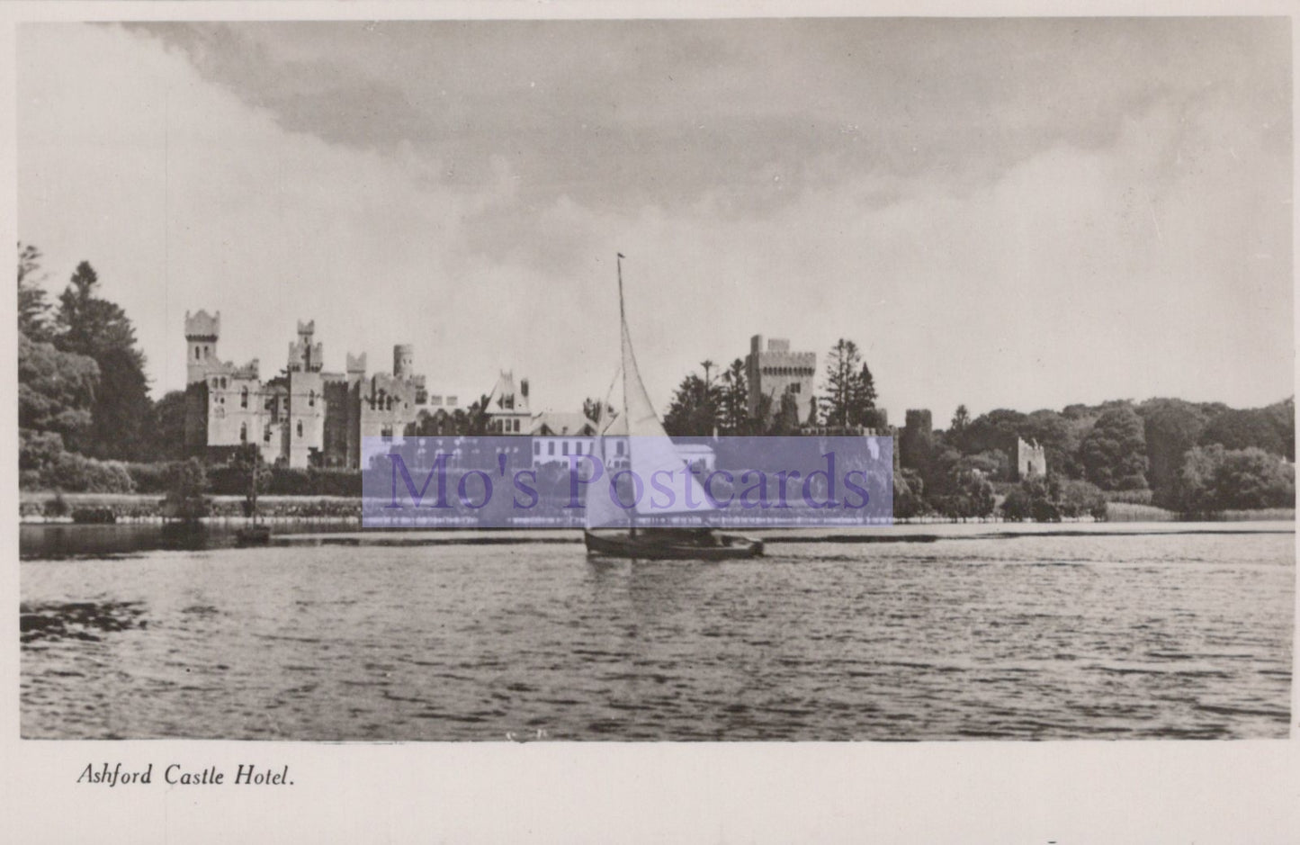 Vintage black and white photo of a castle by a body of water with 'Mo's Postcards' logo.