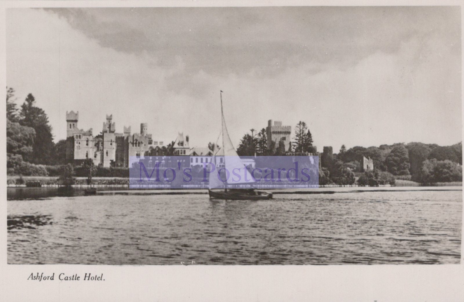 Vintage black and white photo of a castle by a body of water with 'Mo's Postcards' logo.