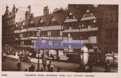 Vintage black and white photo of Holborn Bars with old London houses and a prominent sign.