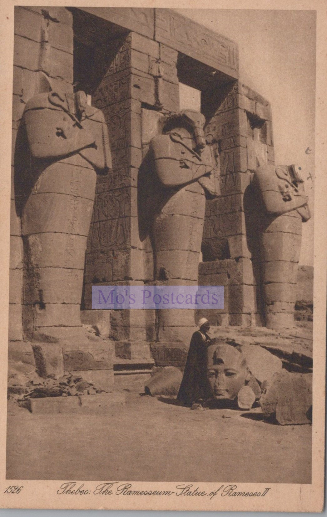 Vintage photograph of colossal statues at Ramesseum with a person for scale.