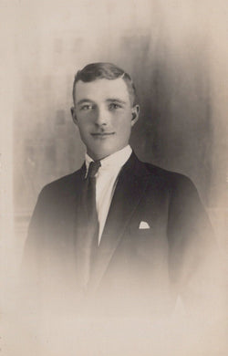 Vintage black and white portrait of a man in formal attire against a plain background