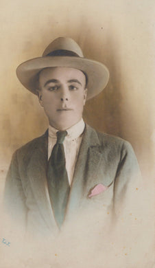 Man wearing a hat, suit, and tie in a vintage portrait