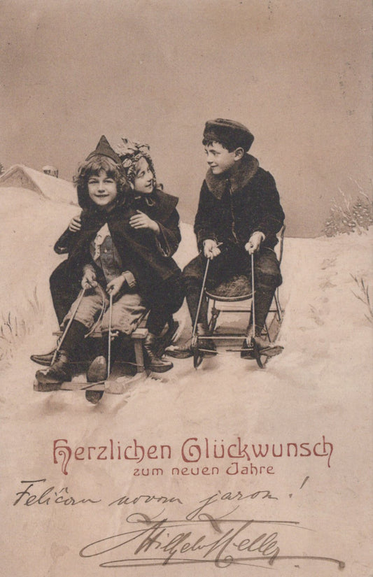 Two children on sleds in a snowy landscape with a vintage postcard style.