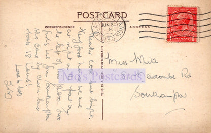 Vintage postcard with handwritten text and a red stamp on a beige background