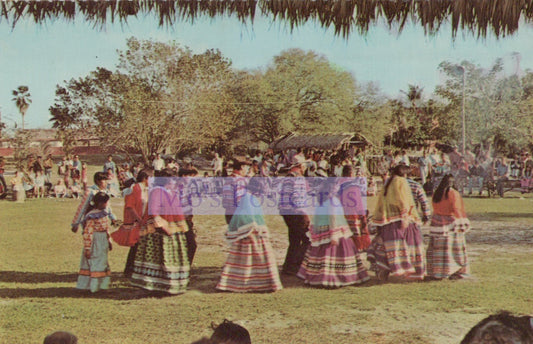 Group of people in colorful traditional clothing standing in a circle outdoors.