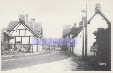 Vintage black and white photograph of a street with houses and a road.