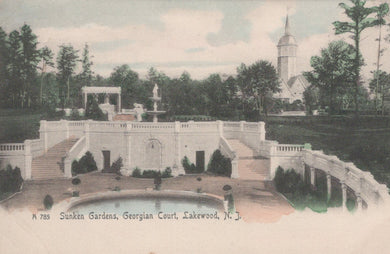 Vintage postcard of Sunken Gardens at Georgian Court in Lakewood, NJ with a church in the background.