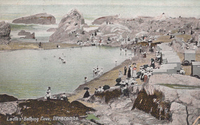 Vintage postcard of a coastal scene with people at a bathing cove, featuring rocky terrain and a body of water.