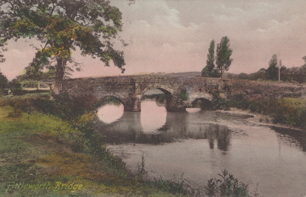 Stone bridge over a calm river with trees and grass on either side, vintage coloration.