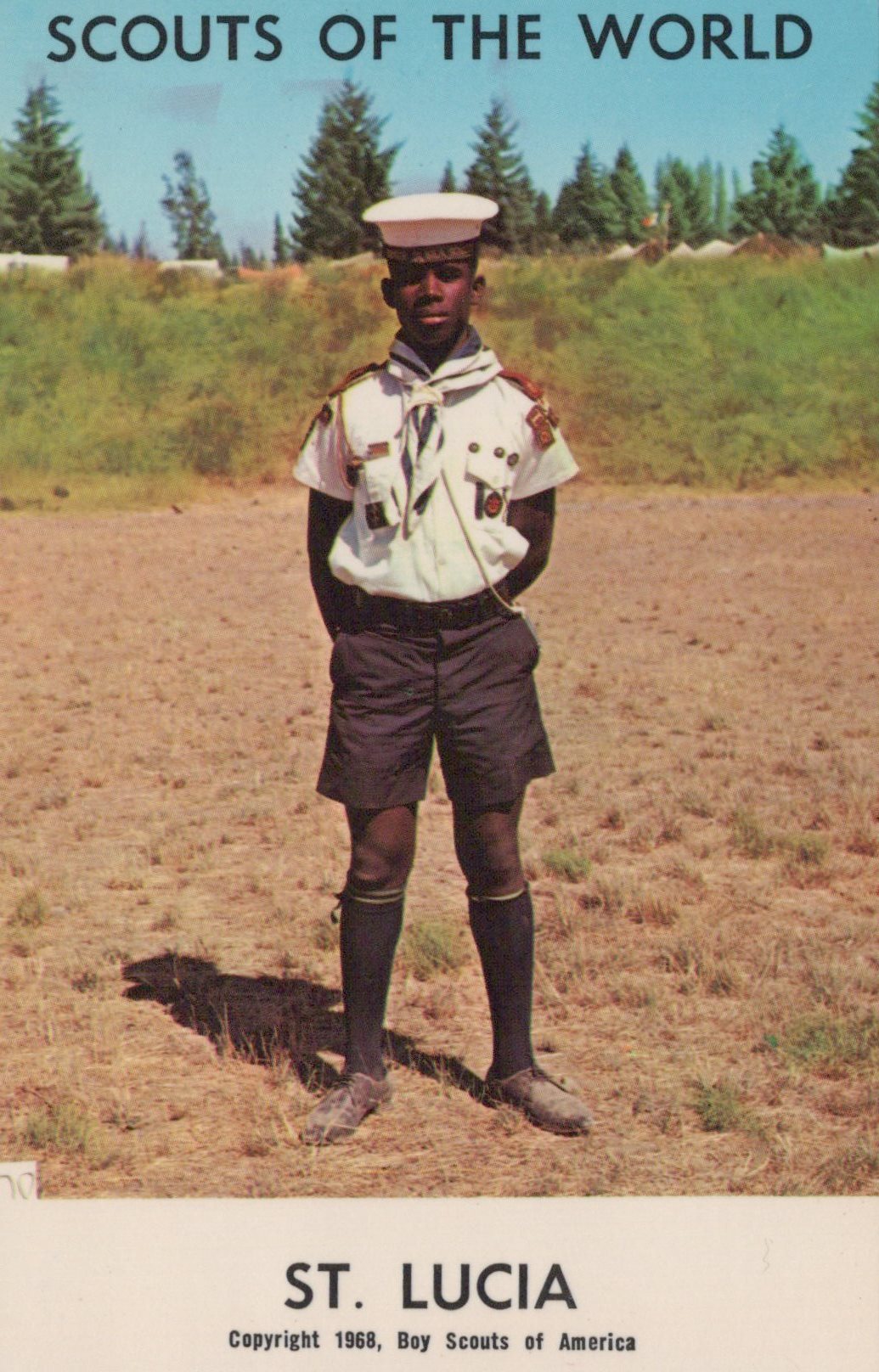 Scout in uniform standing in a field with 'Scouts of the World' and 'St. Lucia' text at the top.