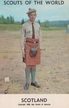Load image into Gallery viewer, Scout in uniform with a kilt standing outdoors, with &#39;Scouts of the World&#39; and &#39;Scotland&#39; text at the top.
