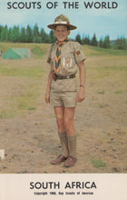 Load image into Gallery viewer, Scout in uniform standing outdoors with trees and tents in the background, labeled &#39;Scouts of the World, South Africa&#39;.
