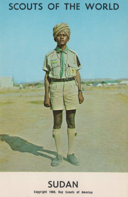 Scout in uniform with a turban standing on a road, with text 'Scouts of the World Sudan' at the bottom.