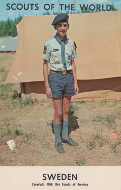 Scout in uniform standing in front of a tent with 'Scouts of the World' and 'Sweden' text.