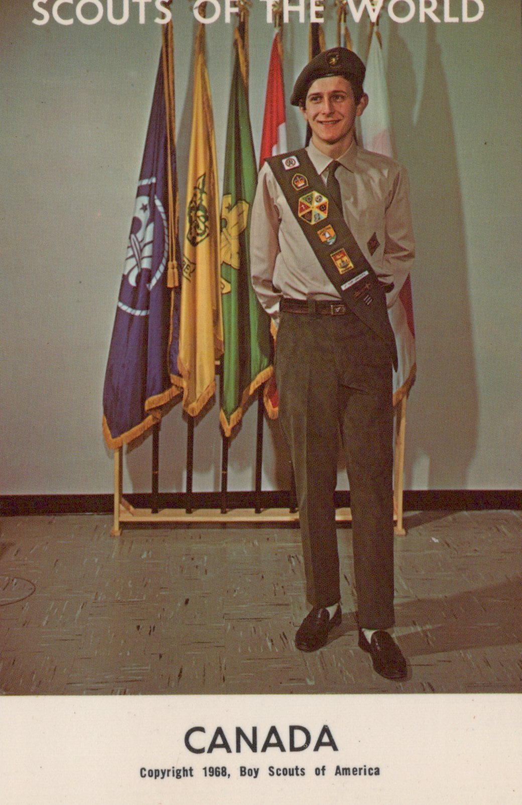 Scout standing in front of flags with 'Scouts of the World' and 'Canada' text.