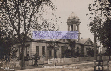 Vintage photograph of a school building with a clock tower, surrounded by trees.